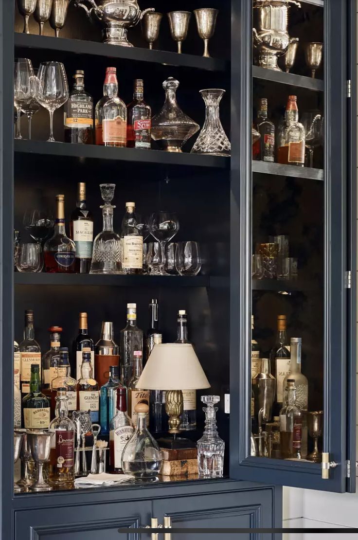 a cabinet filled with lots of liquor bottles and glasses on top of it's shelves