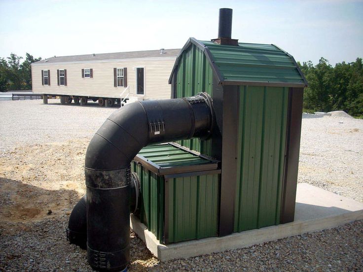 a green building with a black pipe next to it