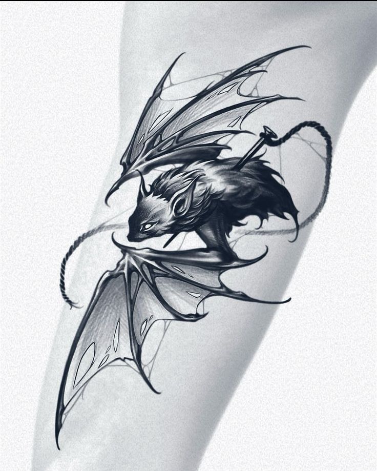 a black and white photo of a dragon tattoo on the leg, with its wings spread out