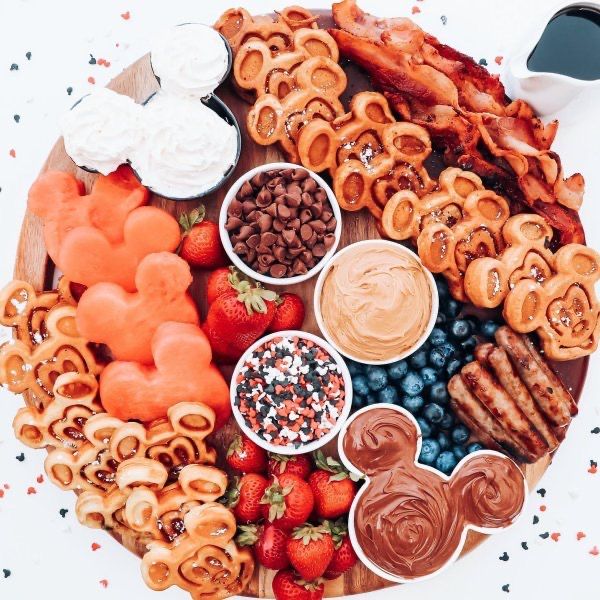 a platter filled with pretzels, strawberries and other snacks