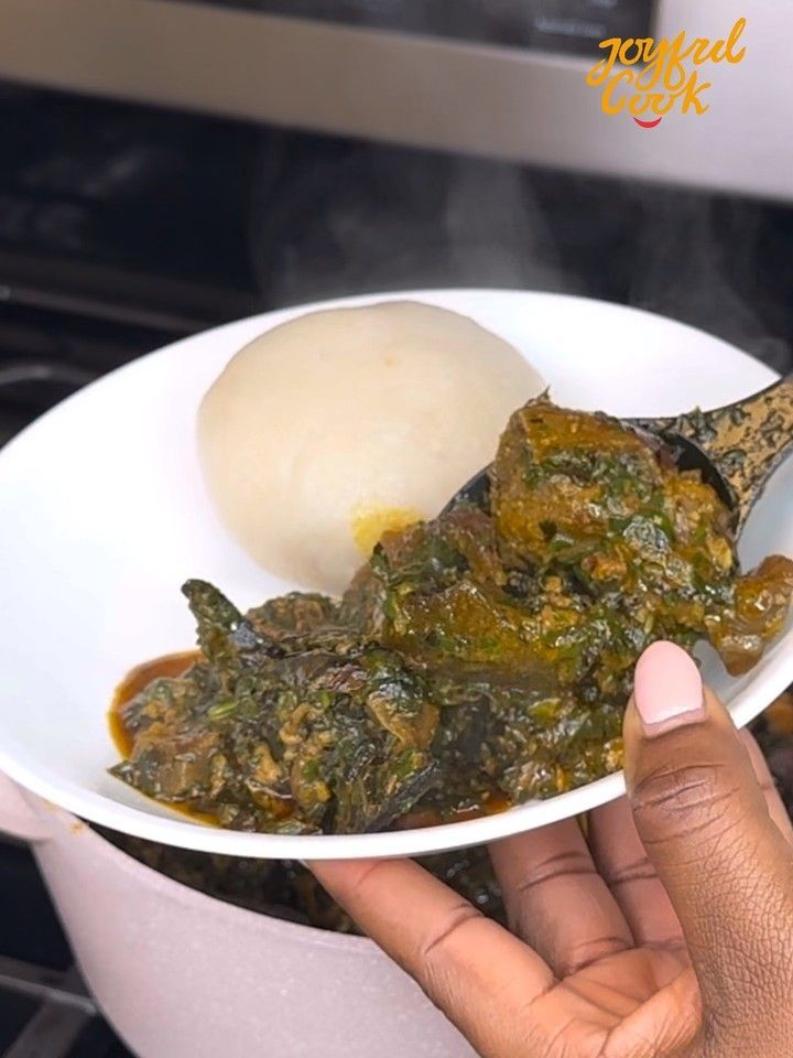 a person holding a white bowl filled with food on top of a stove burner