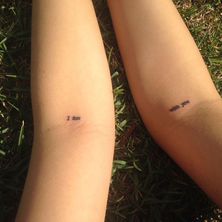 two people with tattoos on their legs are laying in the grass and one has a small tattoo