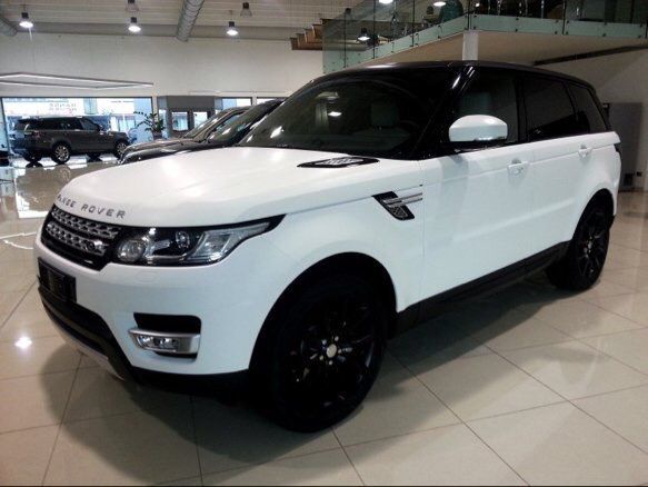 a white range rover parked in a showroom