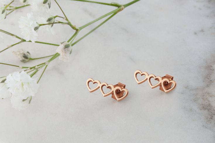 "\"A heart for love. A heart for life. A heart for you. Each heart a symbol to represent what you cherish the most!\" --Fairy Goldcharm ♥♥ CUSTOMIZATION ---> Available in yellow, white, and rose gold. ♥♥ DETAILS These triple heart studs are 1.3cm x 0.5cm (approx. 0.5in x 0.2in). Earring backs included. ♥♥ MATERIALS All our items are made of 9 karats, 14 karats or 18 karats solid gold upon request. We like to use yellow gold, white gold and rose gold to please your color of choice. Use the dro Rose Gold Heart Earrings For Valentine's Anniversary, Rose Gold Heart Earrings For Anniversary And Valentine's Day, Heart-shaped Rose Gold Earrings For Mother's Day, Rose Gold Heart Earrings For Anniversary, Rose Gold Sterling Silver Heart Earrings For Mother's Day, Rose Gold Heart Charm Earrings For Mother's Day, Mother's Day Rose Gold Earrings With Heart Charm, Rose Gold Heart Earrings For Mother's Day, Rose Gold Heart Earrings For Wedding On Mother's Day