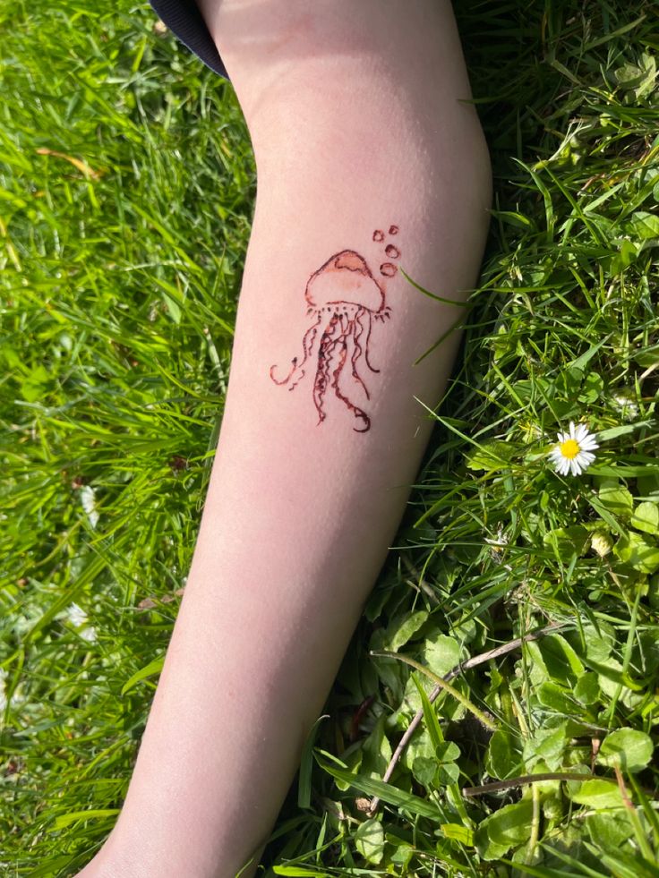 a woman's leg with a tattoo on it that has a jellyfish drawn on it