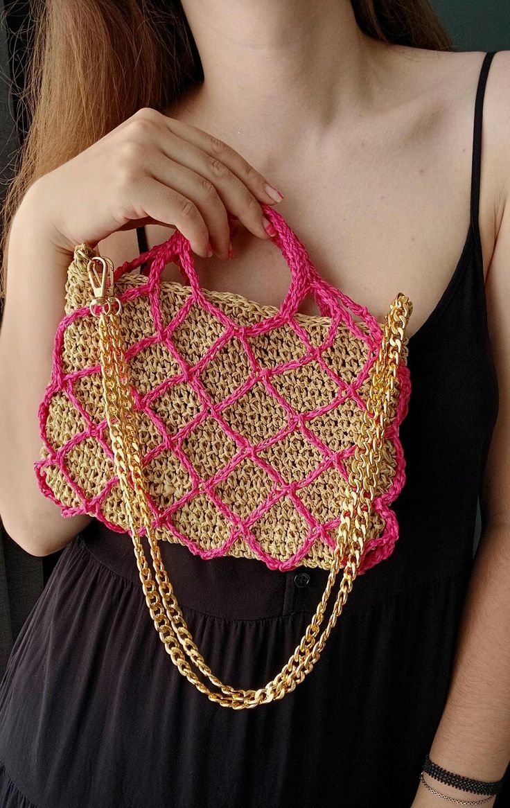 a woman is holding a pink and gold purse