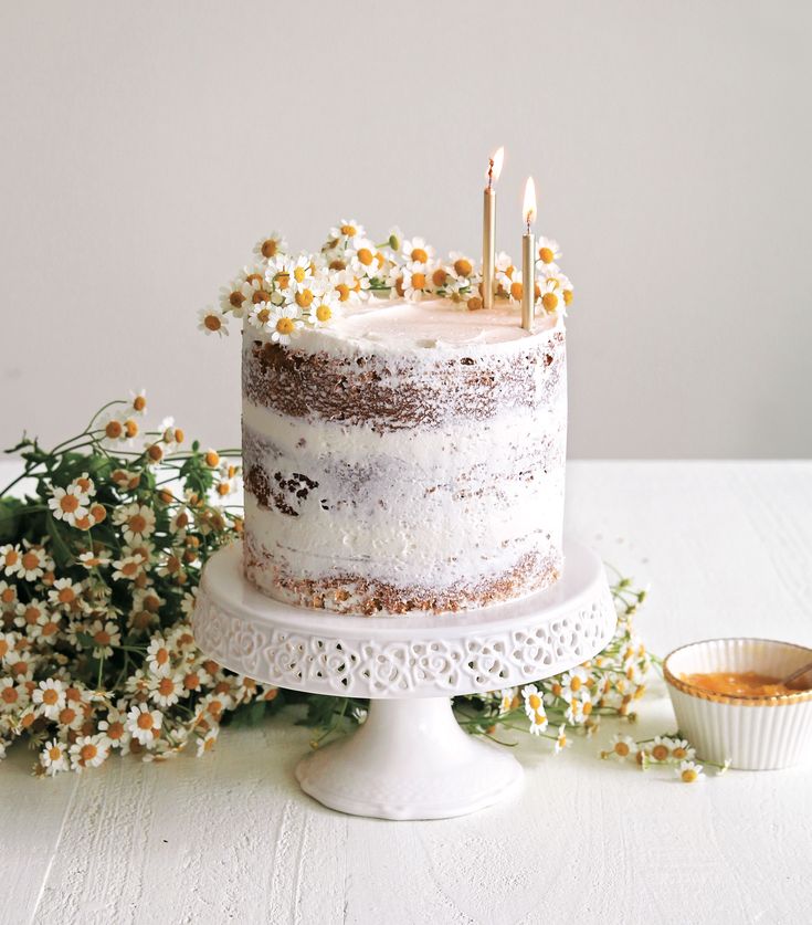 a white cake with flowers and candles on it