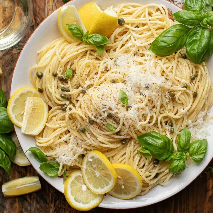 a white plate topped with pasta and lemons