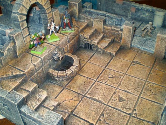 a close up of a model of a castle with figurines on the ground