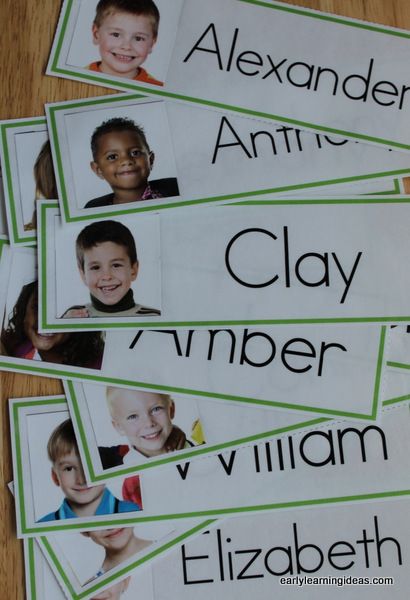 four children's name tags with pictures of them in green and white, on a wooden table