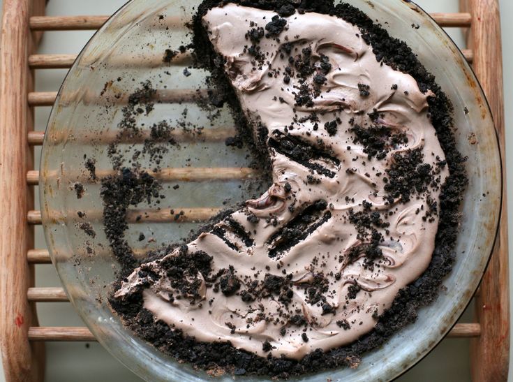 a chocolate cake sitting on top of a metal pan covered in oreo cookies and cream