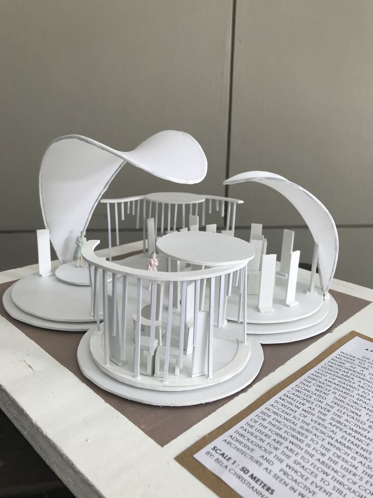 a model of an architectural structure on a table next to a piece of paper and a book