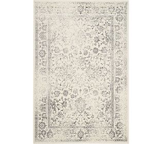 a white rug with an ornate design on the top and bottom, in grey tones