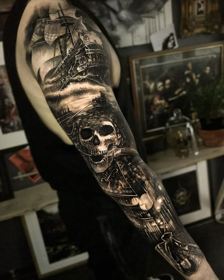 a man's arm with a skull and ship tattoo on it