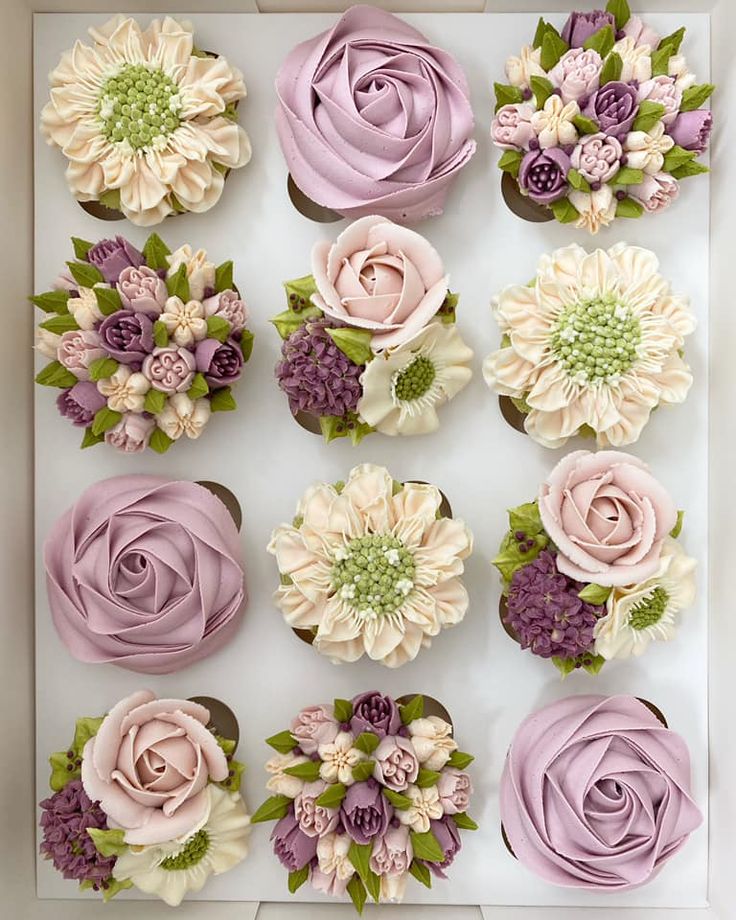 the cupcakes in the box are decorated with flowers