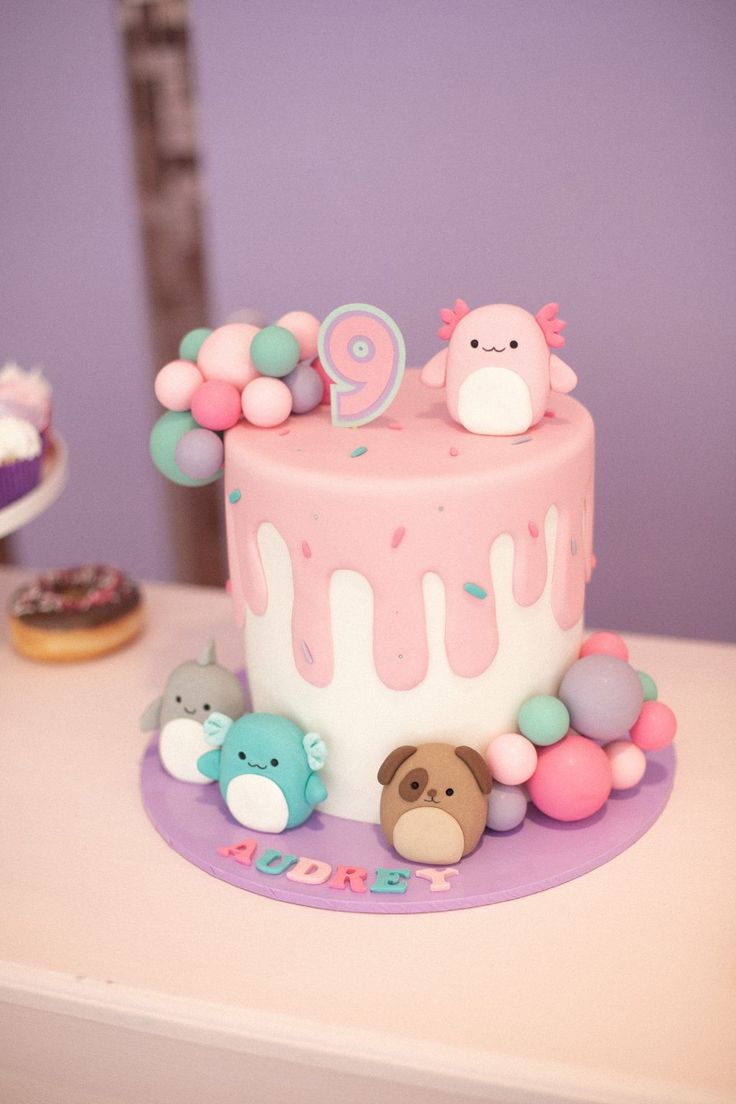 a pink and white cake with decorations on it