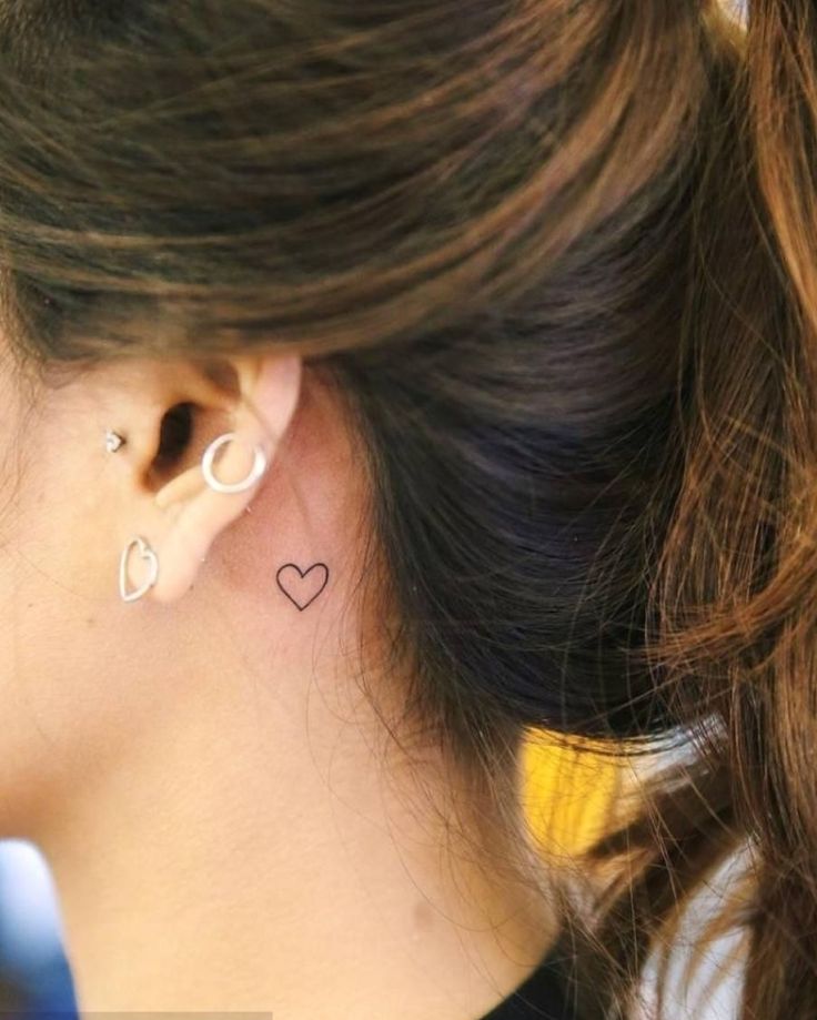 a woman with a heart tattoo on her left ear