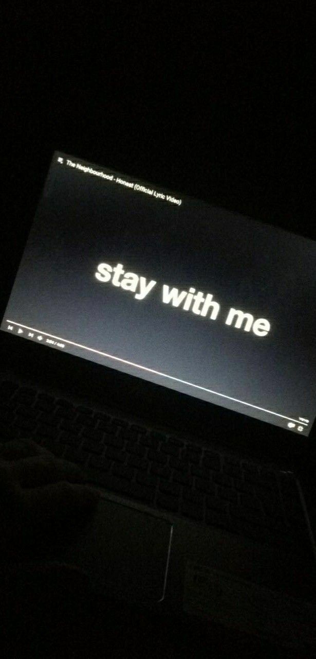 an open laptop computer sitting on top of a dark table with the words stay with me written on it