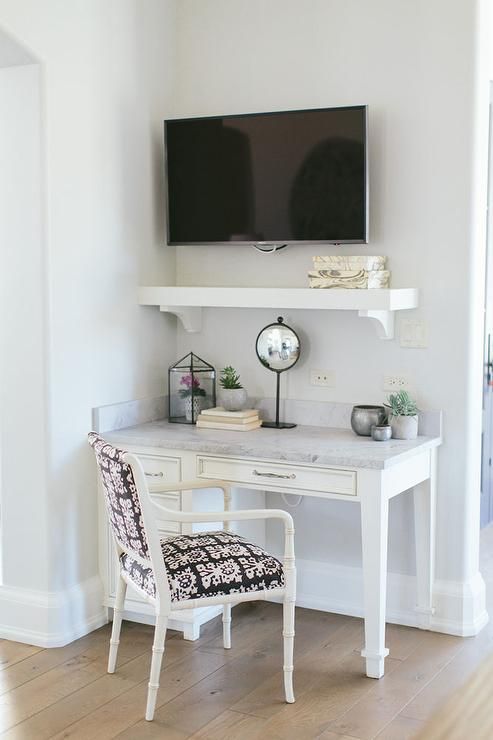 a white desk with a tv on top of it and a chair in front of it