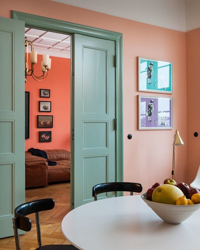 a bowl of fruit sitting on top of a white table in front of a door