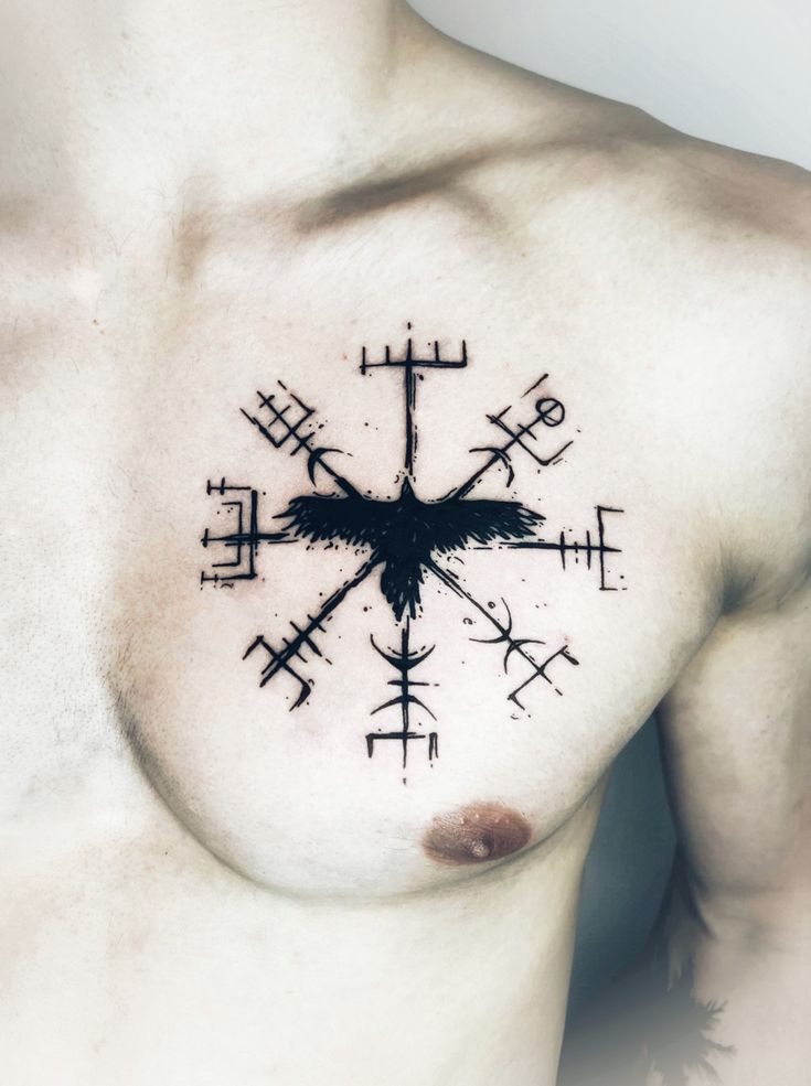 a man's chest with a cross tattoo on it