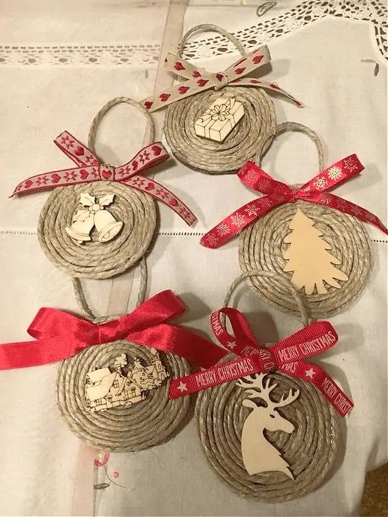 four christmas ornaments with red ribbons and bows on a white tablecloth covered in doily