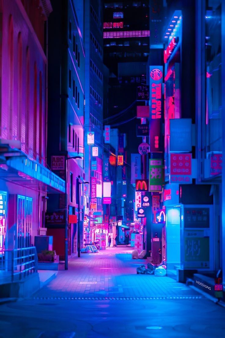 an empty city street with neon signs on the buildings