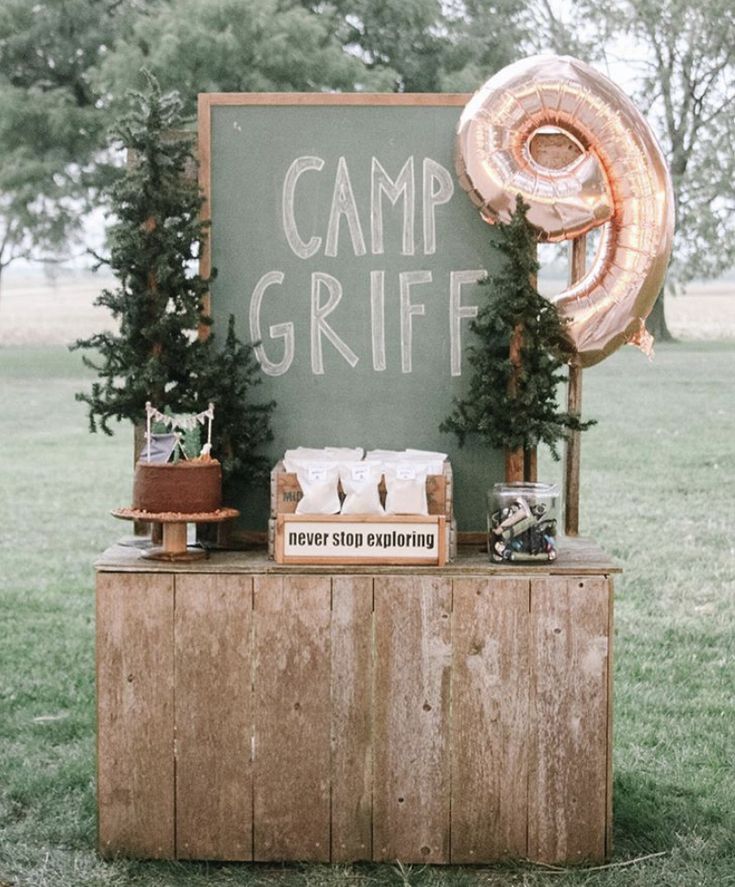 a sign that says camp gritf next to some food on a wooden table with an inflatable balloon