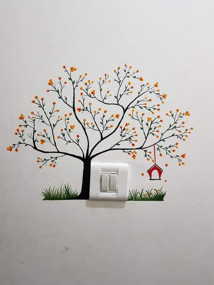 a white light switch sitting on top of a wall with a tree painted on it