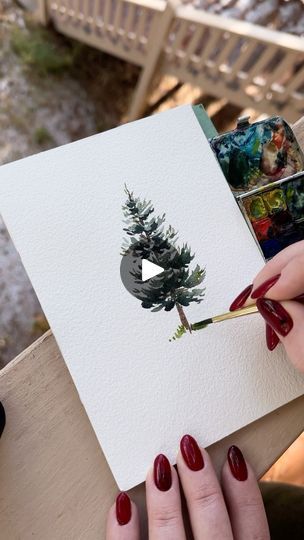 a woman is holding a card with a pine tree on it