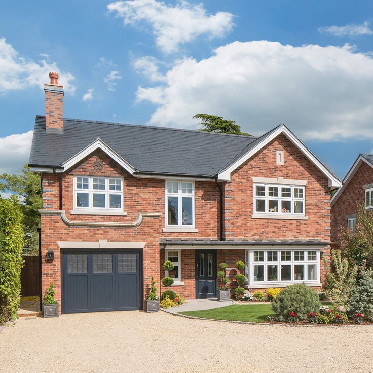 a large brick house with two garages on the front and one car in the driveway