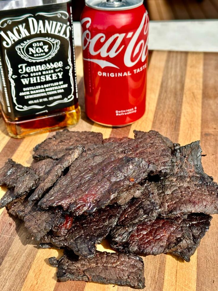 the steak is cut up and ready to be served on the table with two cans of soda