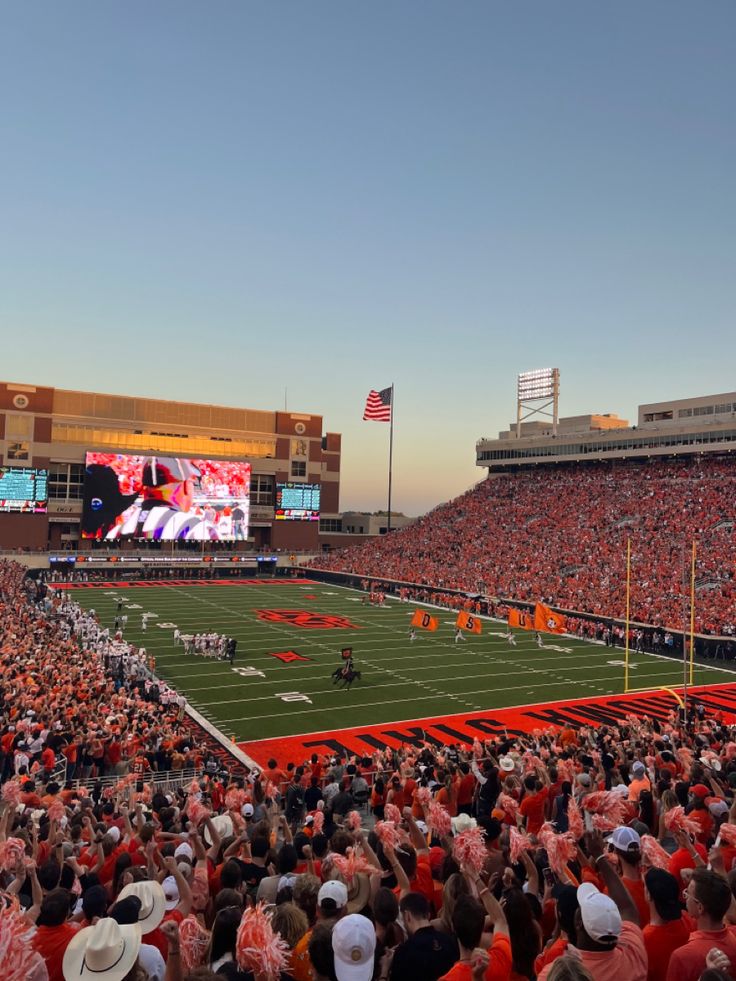 an orange and white football stadium filled with fans