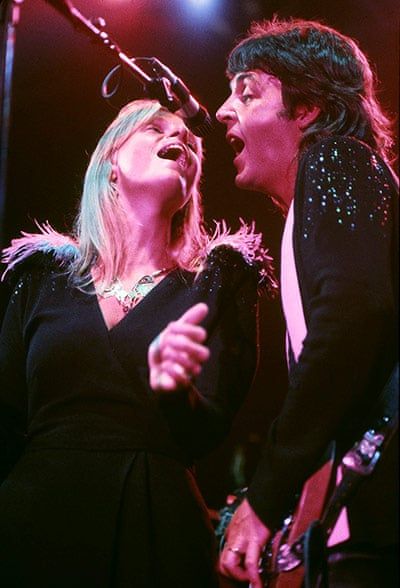 two people singing into microphones on stage