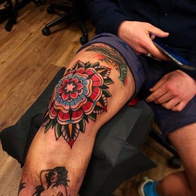 a man with a flower tattoo on his leg