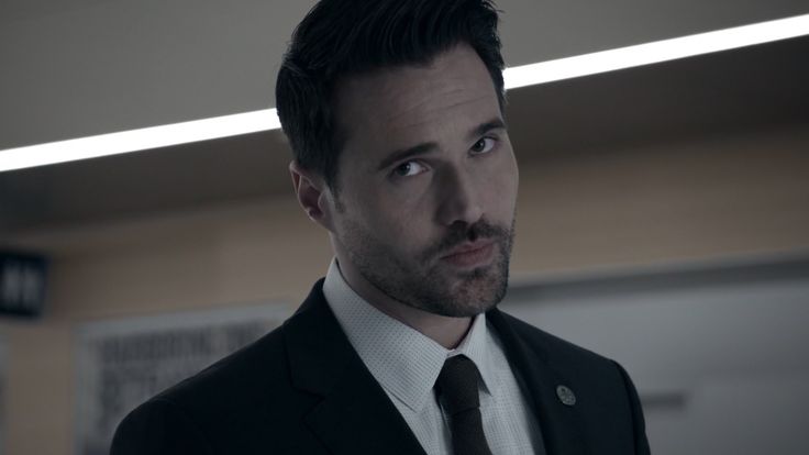 a man in a suit and tie looking at the camera with an intense look on his face