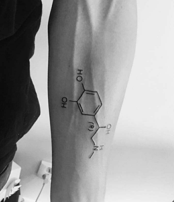 a black and white photo of a person's arm with the chemical formula tattoo on it