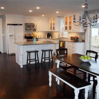 a kitchen with white cabinets and wooden floors