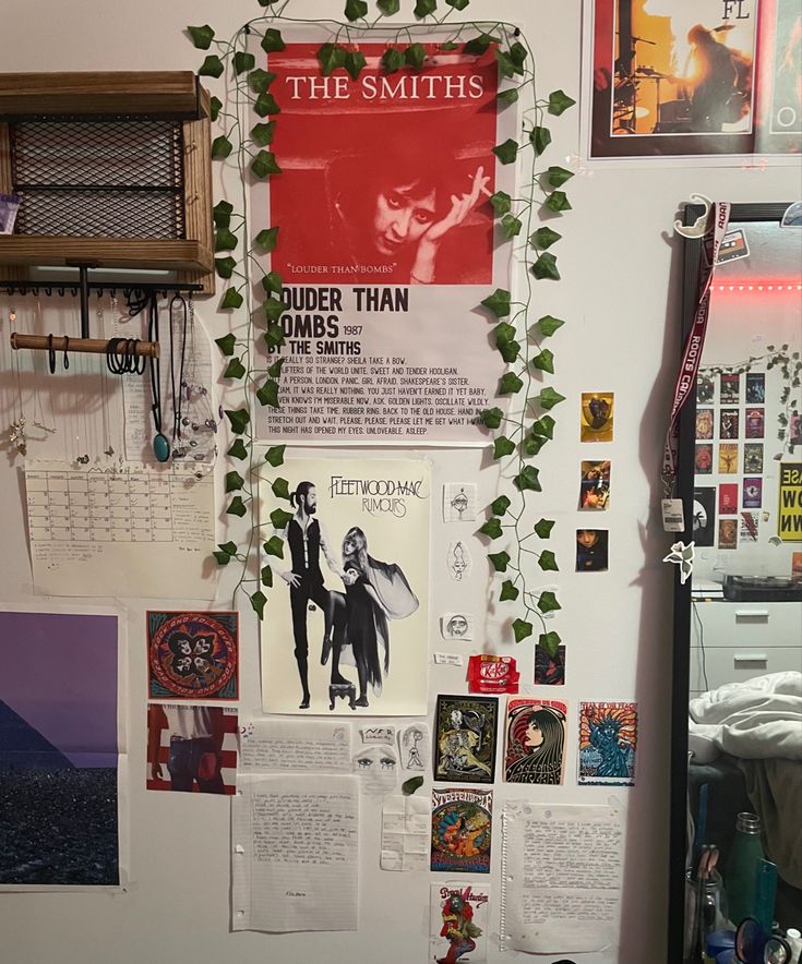 a wall covered in posters and plants next to a window with the smiths poster on it