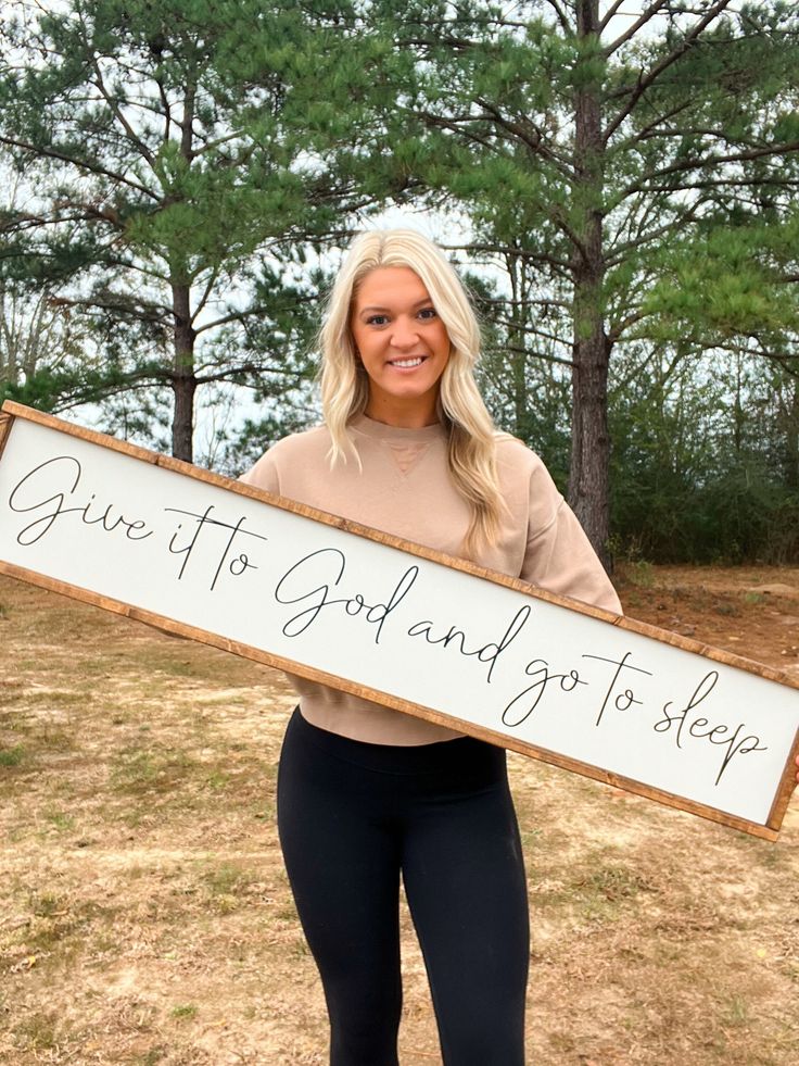 a woman holding a sign that says give it gold and go to sleep