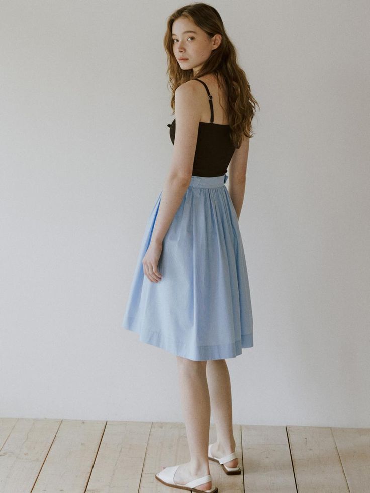 This skirt is designed with a gentle A-line silhouette and crafted from a light blue, subtly textured fabric that adds a soft, airy feel to its appearance. It features a comfortable elastic waistband for an easy fit and a discreet side zipper that ensures a smooth waistline. The skirt's modest length makes it suitable for both casual and formal settings. Additionally, the simple design and refreshing color make it a versatile piece that pairs well with various top styles and accessories.- The elastic waistband and side zipper provide both comfort and practicality, making the skirt easy to wear.- Its light blue color and subtle texture offer a pleasant visual appeal, ideal for spring and summer wardrobes.- The A-line cut flatters a wide range of body types, enhancing the skirt's versatility Spring Blue Voluminous Skirt, Blue Pleated Skirt With Elastic Waistband For Summer, Blue Relaxed Pleated Skirt With Elastic Waistband, A-line Skirt With Elastic Waistband For Daywear, Blue Flowy Pleated Skirt With Elastic Waistband, Flowy A-line Skirt For Daywear, Blue Cotton Bottoms With Pleated Waist, Blue Pleated Skirt With Elastic Waistband, Light Blue Skirt For Spring Workwear