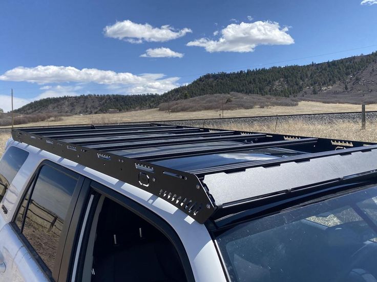 there is a truck with the roof rack on it's flatbed in front of a field