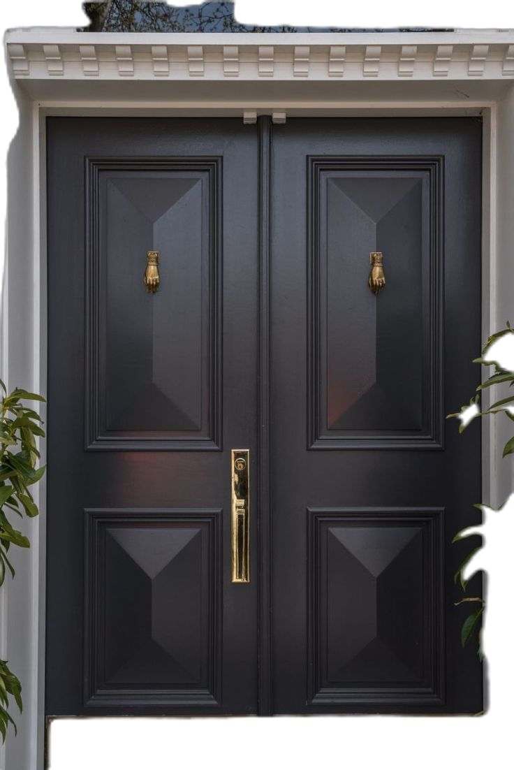 the front door is painted black and has two large doors with brass handles on each side