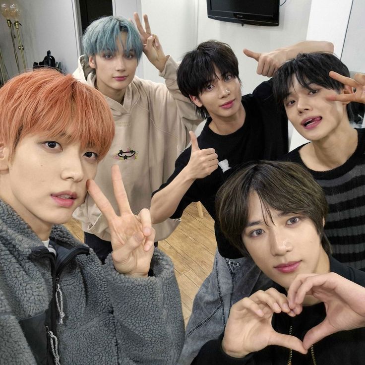 group of young men making peace signs with their hands