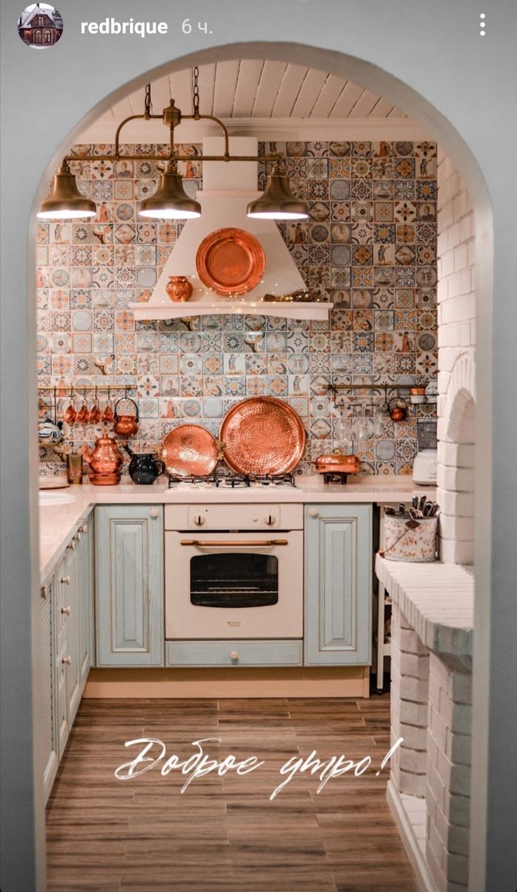 a kitchen with copper pots and pans on the wall