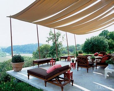 an outdoor area with chairs and tables under a large awning that is open to the outdoors