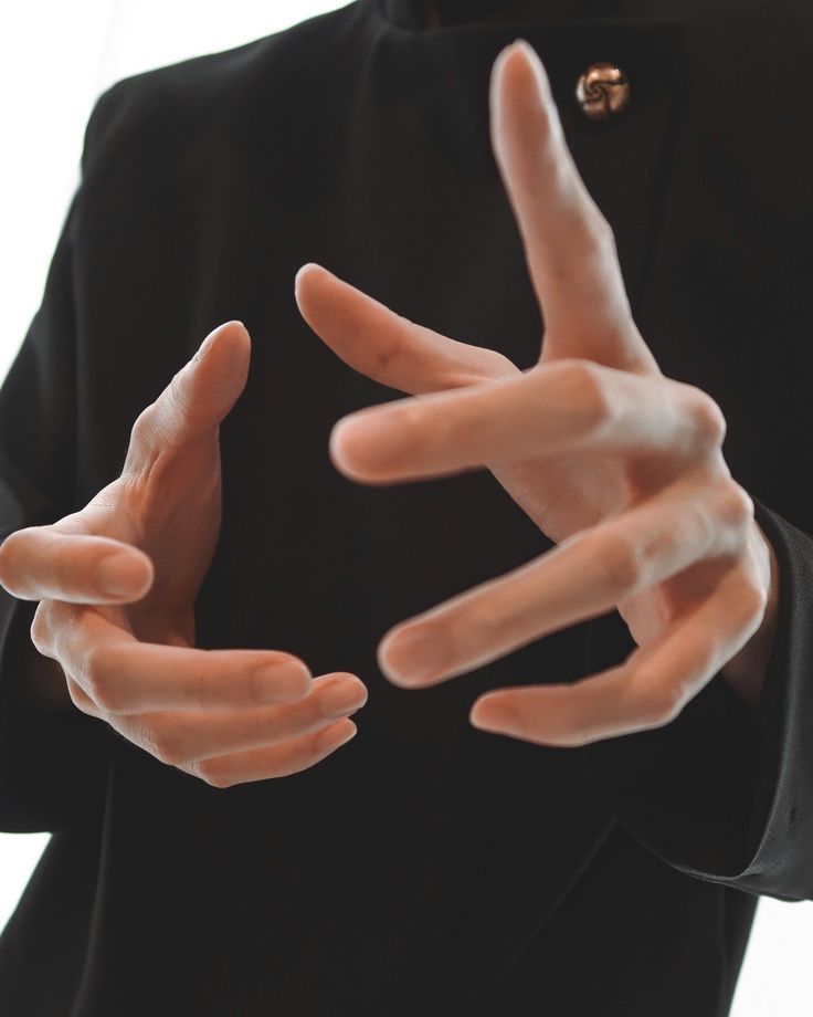 a person in a black suit is holding out their hands to show the peace sign