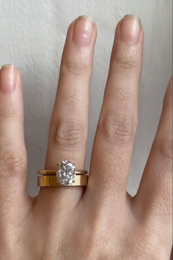 a woman's hand with a ring on it and a diamond in the middle