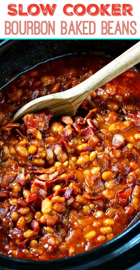 slow cooker bourbon baked beans in a crock pot with a wooden spoon on top