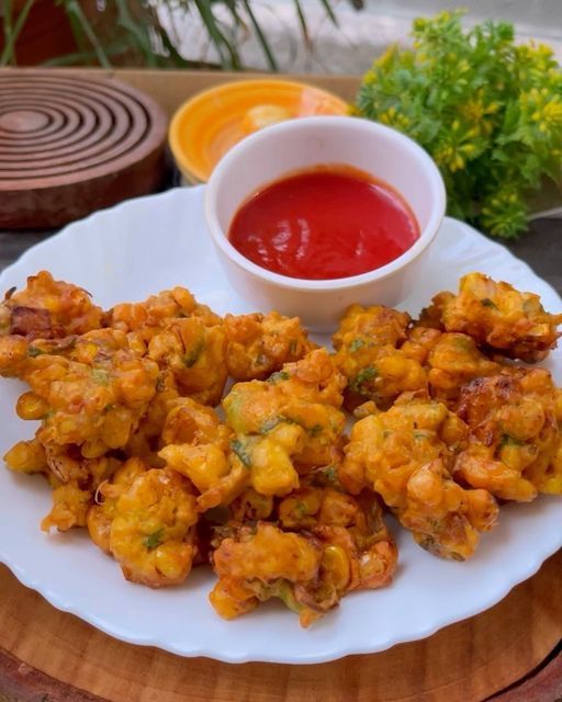 fried food on a white plate next to a bowl of sauce